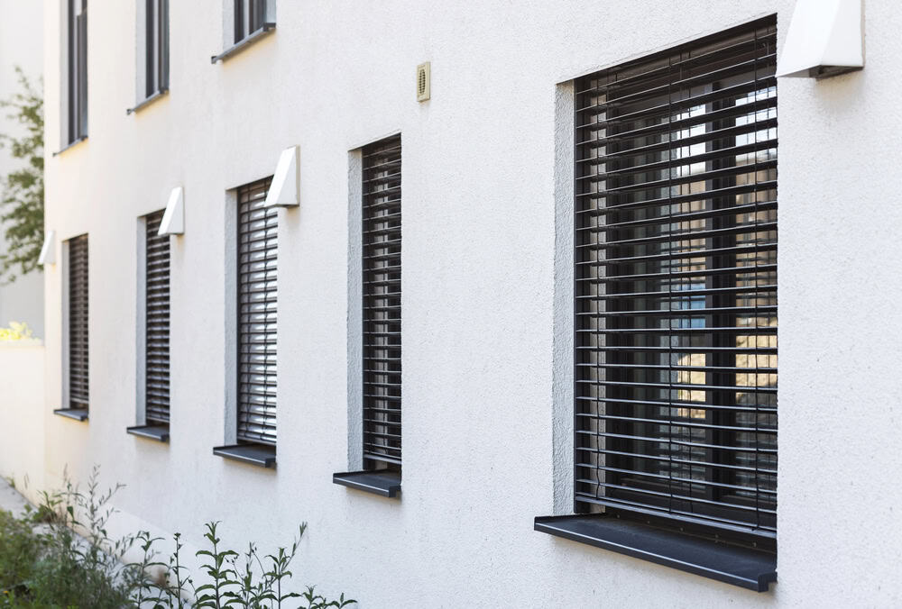 Contemporary residential building featuring white walls and stylish black external venetian blinds.
