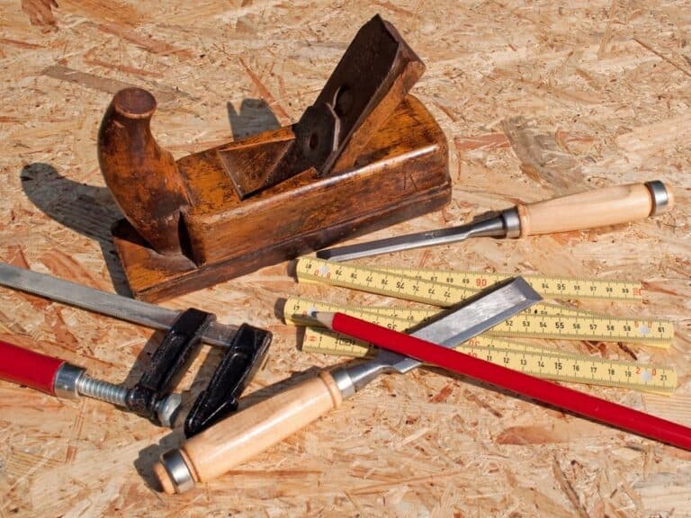 Hand plane and woodworking tools on a plywood surface for carpentry and woodworking projects.